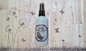 Body spray bottle on a wooden background with butterfly decorations