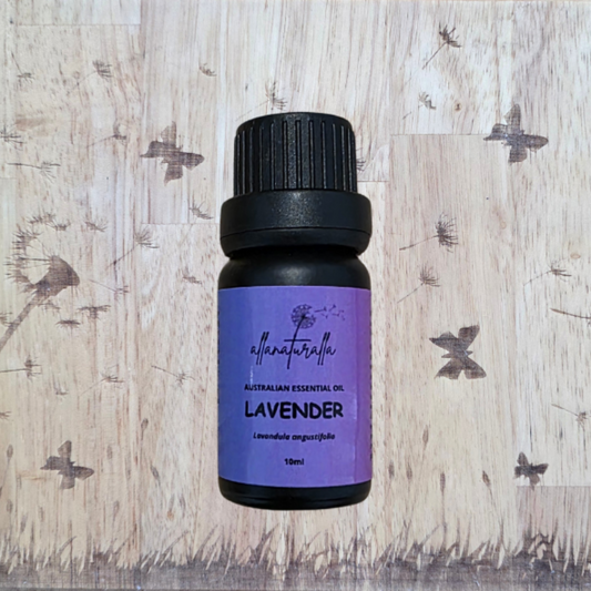 Lavender essential oil bottle on a wooden background with dandelion flowers.